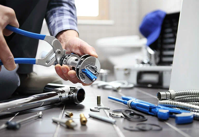 Technician repairing a plumbing fixture with professional tools in Alpharetta