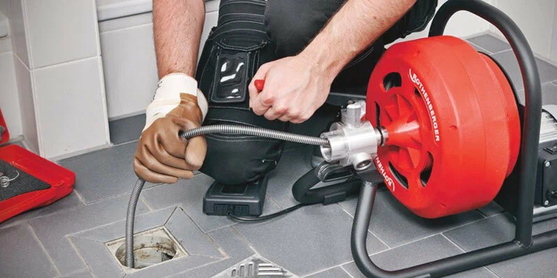 Plumber using a drain-cleaning machine in Alpharetta
