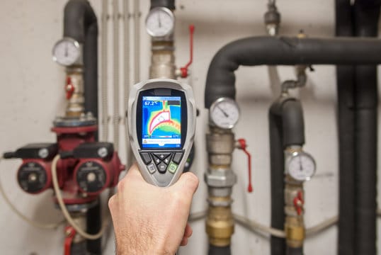Plumber using a thermal imaging camera to inspect pipes in Alpharetta