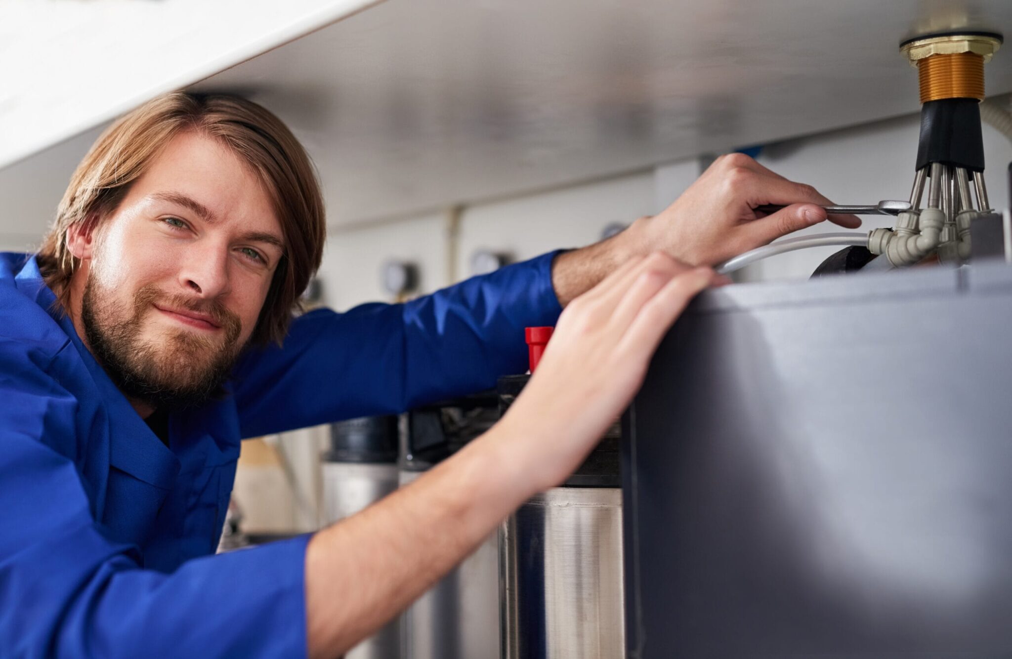 Technician servicing a residential water heater tank in Alpharetta