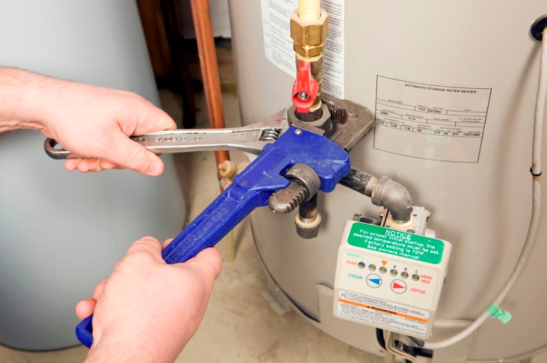 Plumber repairing a water heater valve in Alpharetta